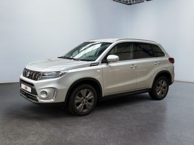 Le SUV blanc est garé dans une grande pièce équipée d'un ventilateur de plafond.