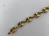 a close up of a gold chain on a white surface