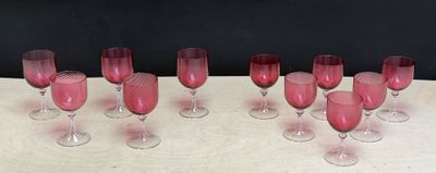 several wine glasses are lined up on a table with a black background