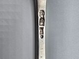 a silver spoon with a silver handle on a table