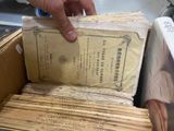 a person that is holding a box with some papers