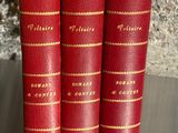 trois livres rouges posés les uns à côté des autres sur une table