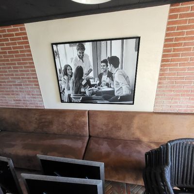 un canapé et un fauteuil dans une pièce où il y a un tableau accroché au mur