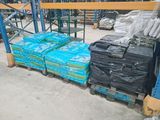 many stacks of luggage sitting on a pallet in a warehouse