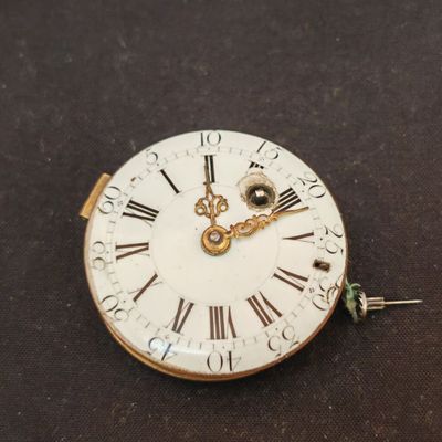 une horloge blanche dont le cadran est orné de chiffres romains