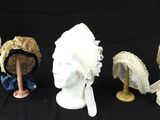 quatre figurines représentant des personnages coiffés de chapeaux et dotés d'ailes, sur fond noir