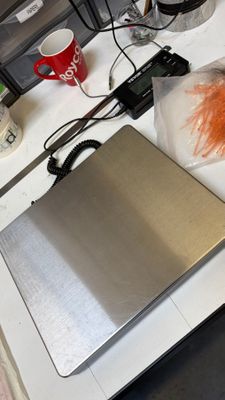 un ordinateur portable posé sur un bureau, à côté d'un sac de carottes
