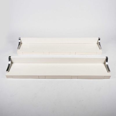 two white shelves with metal brackets on them against a white wall