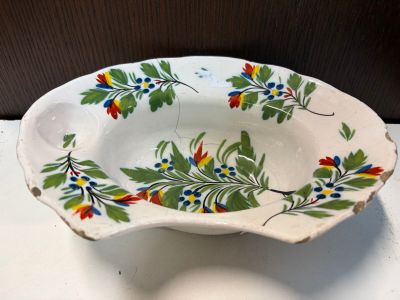 a white bowl with colorful flowers on it on a table