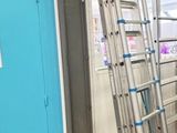 une échelle appuyée contre un mur bleu dans une pièce