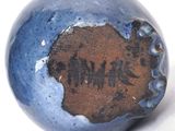 a close up of a blue and brown vase with writing on it