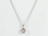 a close up of a necklace on a white surface