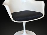 une image représentant une chaise blanche avec une assise noire sur fond noir