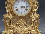 a gold clock sitting on top of a table