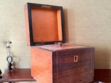 a small wooden box sitting on a shelf next to a clock