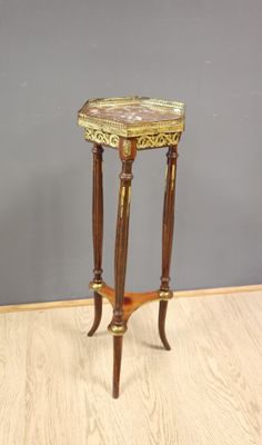 une image représentant une petite table posée sur un parquet, devant un mur gris