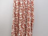 an orange and white floral print skirt hanging on a hanger