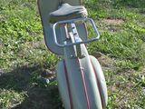 a scooter that is sitting in the grass by the road