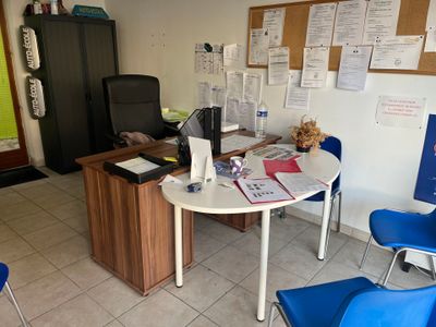 un bureau avec un ordinateur portable et plusieurs chaises dans une pièce