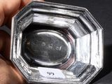 a person holding a silver ashtray in their hand