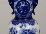 a blue and white vase with a bird on it