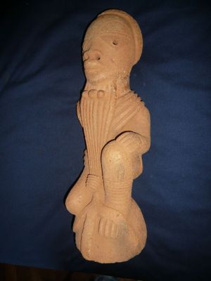 une vieille statue représentant un homme barbu coiffé d'un chapeau