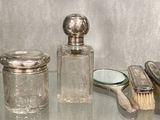 une table en verre sur laquelle sont disposés de nombreux objets en argent