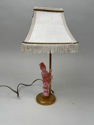 lampe en forme de figurine rose avec un abat-jour blanc et un pied doré