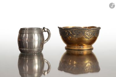 une coupe en argent et une chope en argent posées sur une surface réfléchissante
