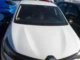 a white car parked in a parking lot with other cars