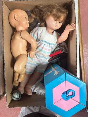 a doll and a doll in a box on the floor