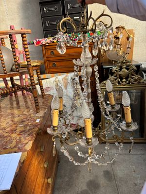 un homme debout à côté d'une table sur laquelle est posé un lustre