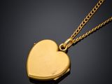 a gold heart locke with a chain on a black background