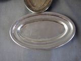 a silver plate and a silver bowl on a table
