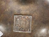 a brown vase that has a chinese writing on it