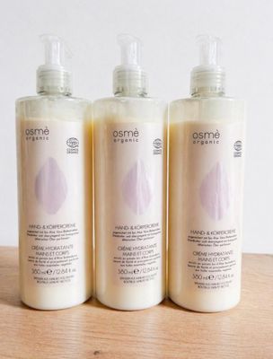 trois flacons de lait corporel posés sur une table en bois