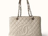 a white chanel bag with a chain handle on a white background