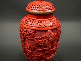 a red vase with a dragon on it on a black background