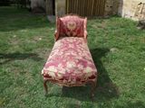 a red and gold chaise lounger in the grass