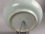 a green bowl with a metal stand on a white surface