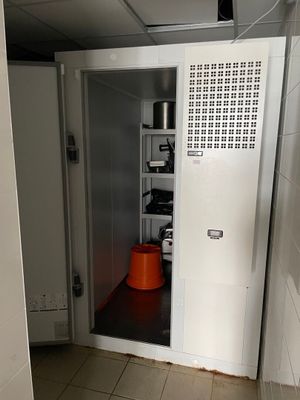 un seau orange posé sur le seuil d'une petite pièce