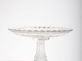 a glass cake stand with a glass bowl on it