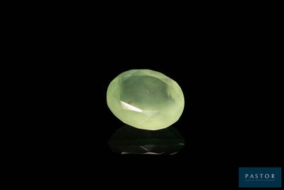 un gros plan d'une pierre de jade verte sur une surface noire