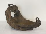 statue représentant une femme assise dans un bateau, les mains sur la tête