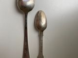 two spoons and a spoon rest on a white surface