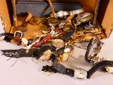 une valise remplie de montres de toutes sortes et d'autres objets