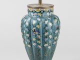 une image représentant un vase bleu avec un socle doré sur fond blanc