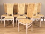 six chairs with woven seats sit in a row on a hard wood floor