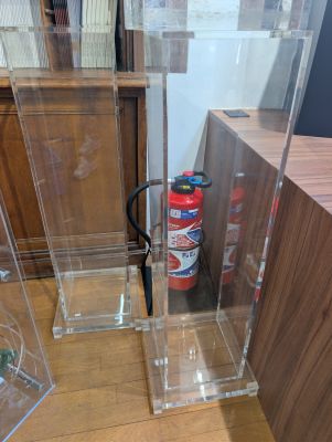 a fire extinguisor and a fire hydrant in the corner of a room