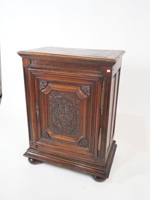 a small wooden cabinet with a carved design on it
